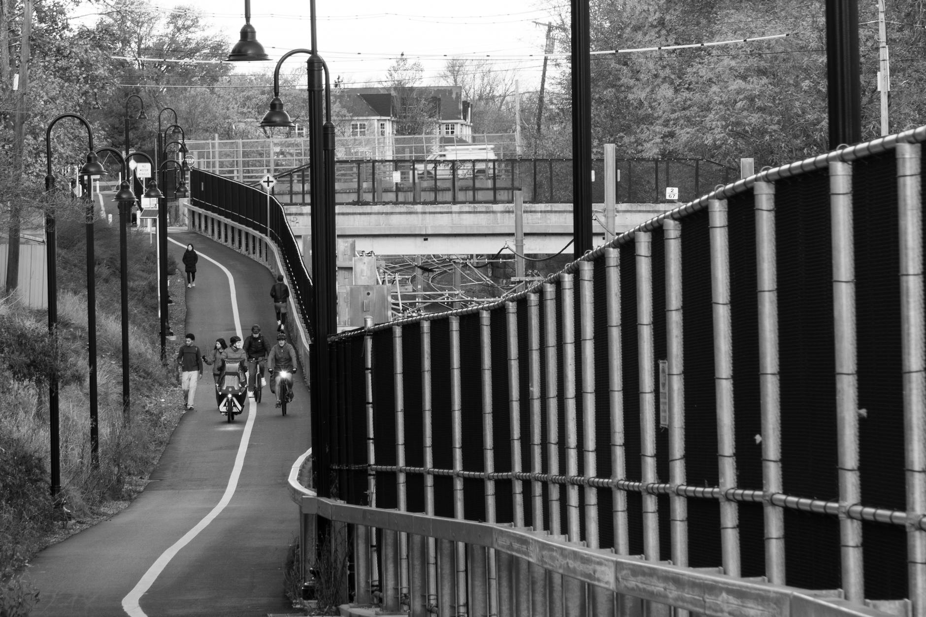 Black and white image of cyclists and pedestrians on a bike path in Somerville, Massachusetts.